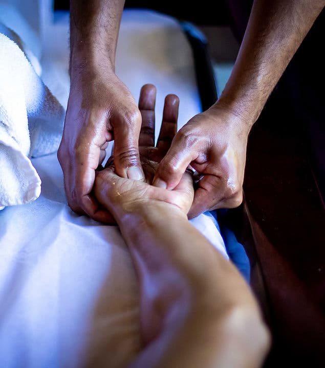 Therapist applying firm, focused pressure during a deep-tissue massage session.